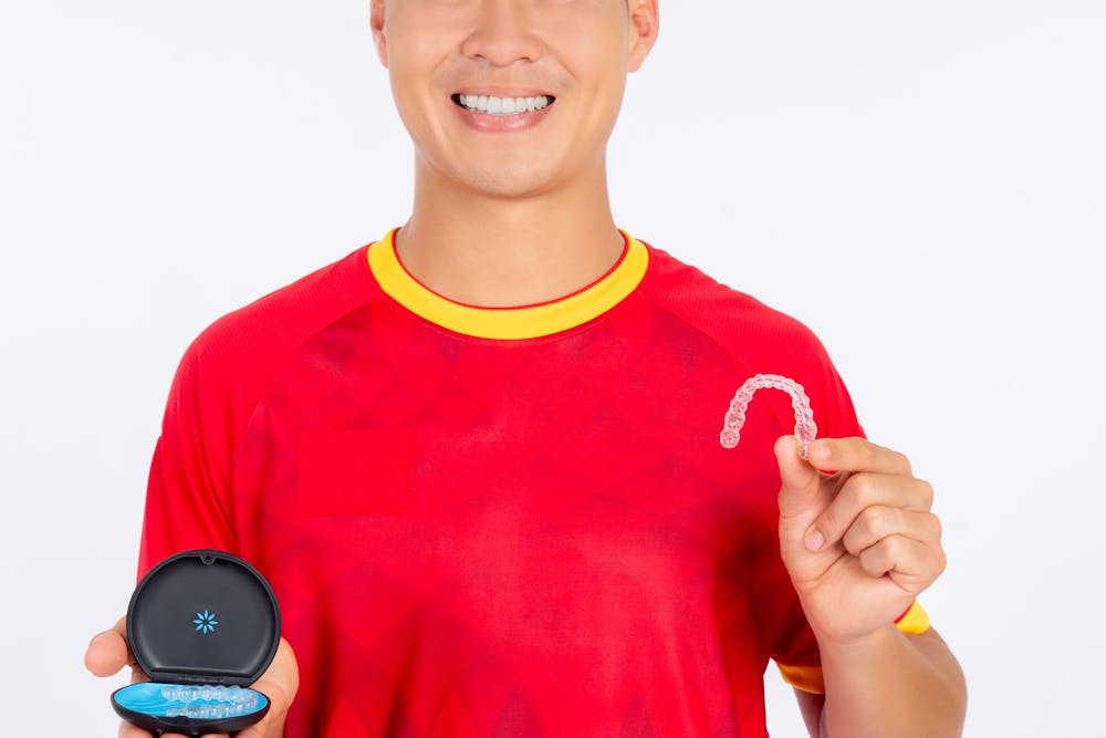 a guy holding a clear aligner