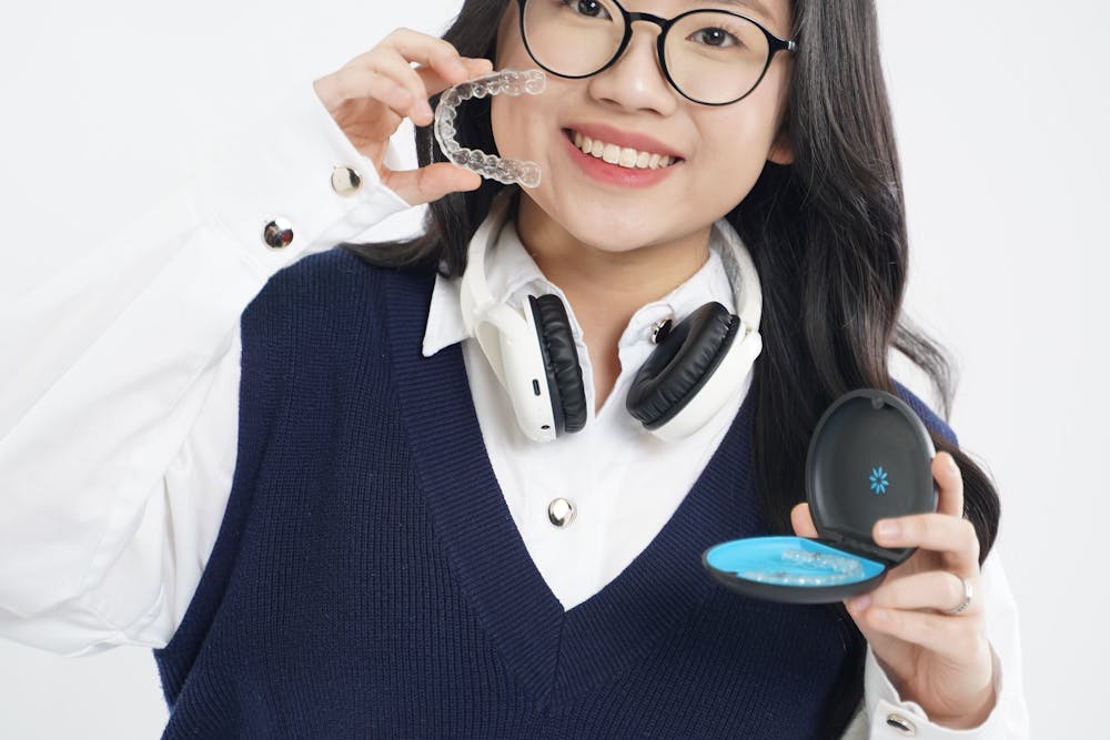a woman holding a clear aligner