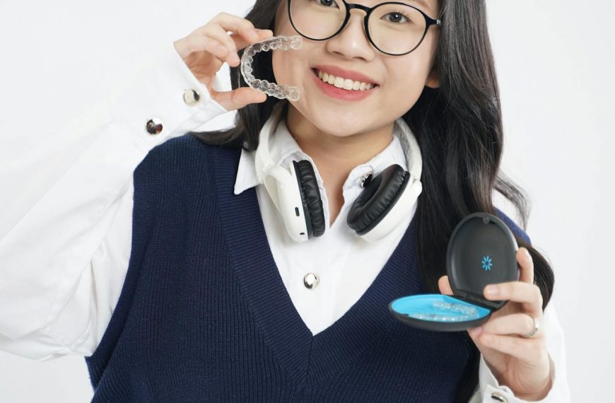 Teen holding clear aligners and an aligner case, demonstrating removable orthodontic trays used before eating and drinking